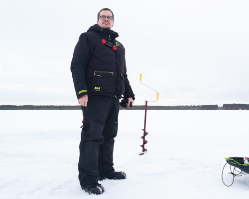 Juha Penttinen seisoo jäällä pilkkihaalarissa, taustalla jääkaira.